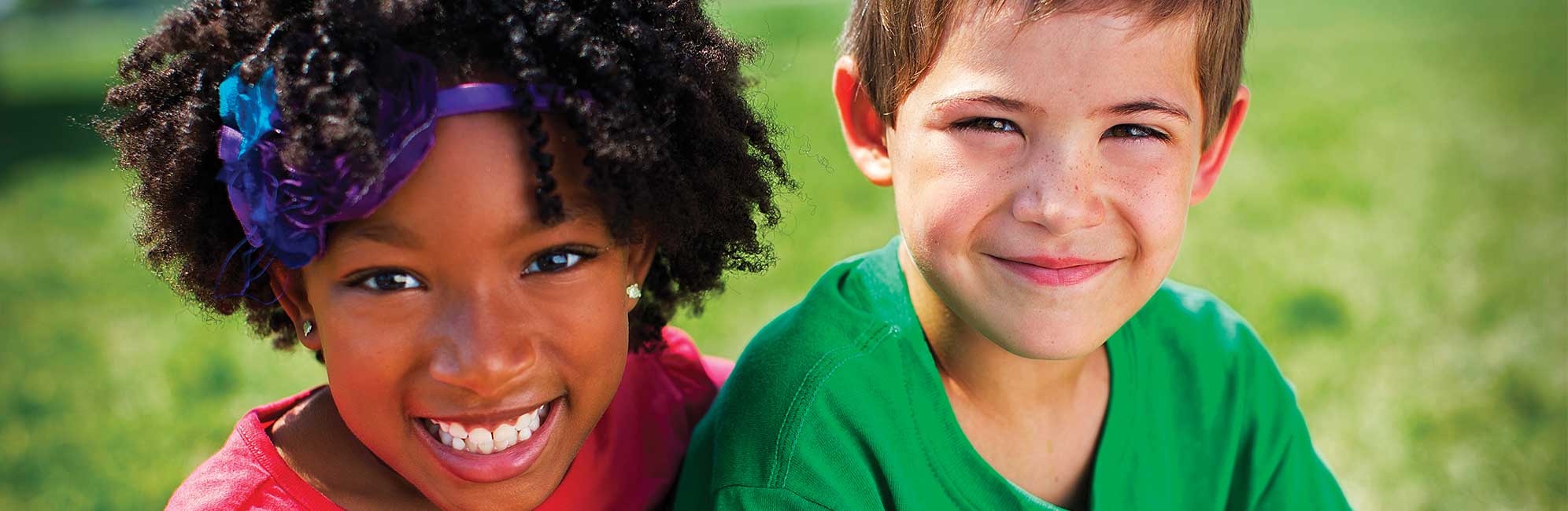 YMCA Youth A boy and girl sit together in a field