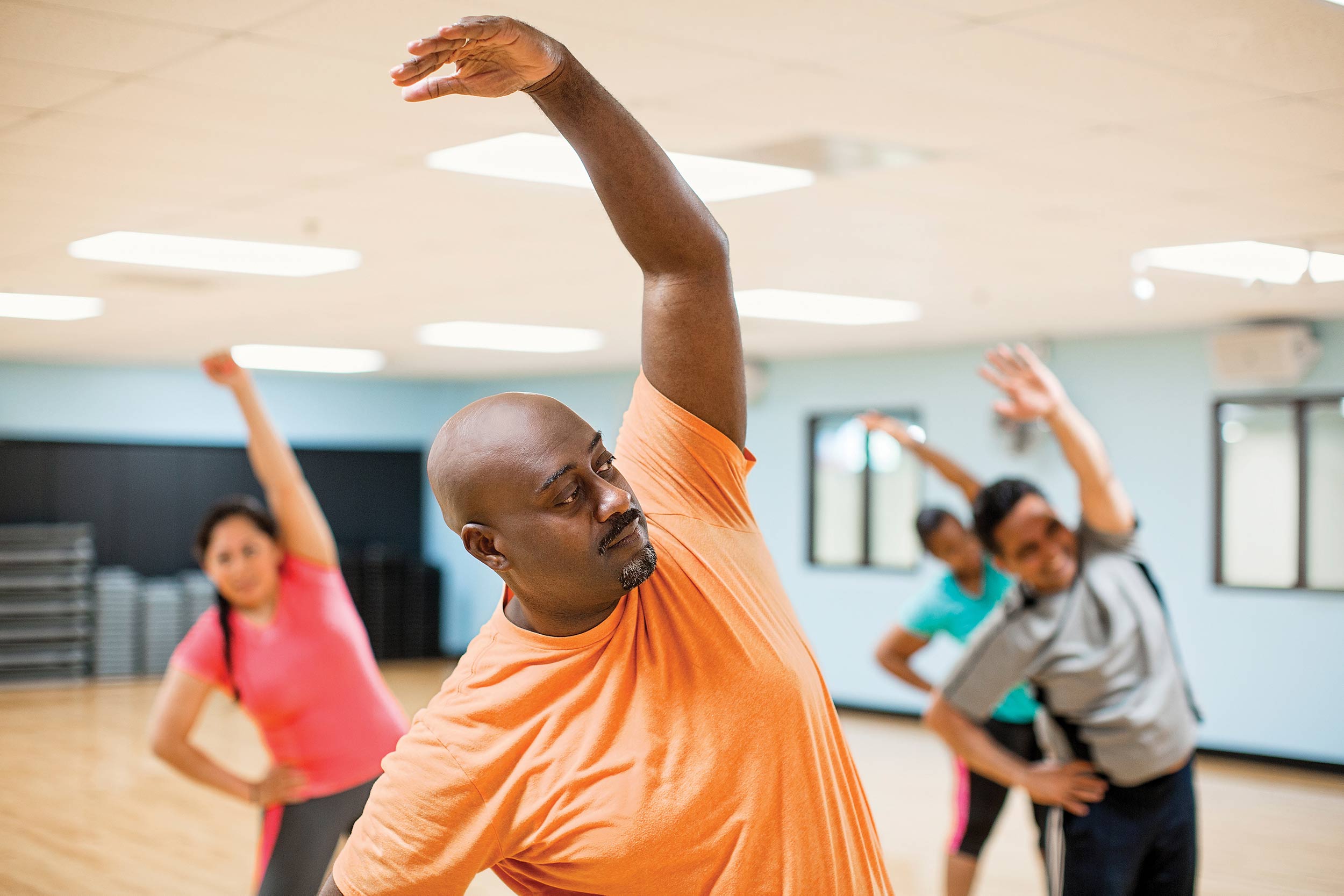 YMCA Group Exercise Class Man stretches during group exercise class
