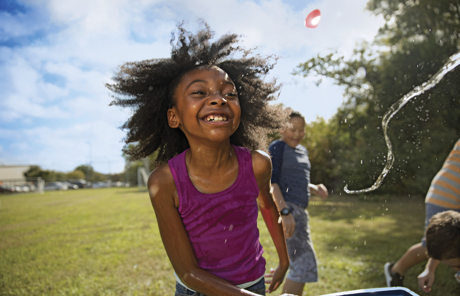 YMCA Summer Day Camps Children play with water balloons on sunny day