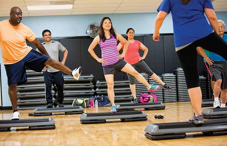 YMCA Group Exercise Class YMCA members participate in a step-aerobics class together
