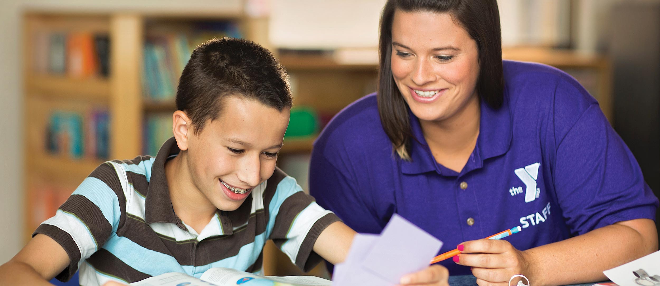 YMCA Volunteer and Youth YMCA Volunteer helps youth with his homework