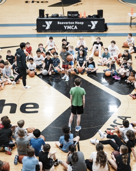 Beaverton Family YMCA - Kids circled up on the gym floor